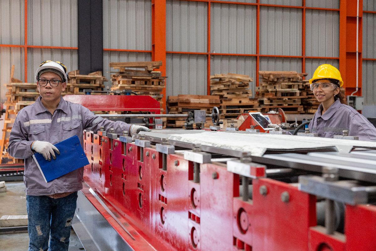 Factory workers inspecting steel materials during fabrication and quality control