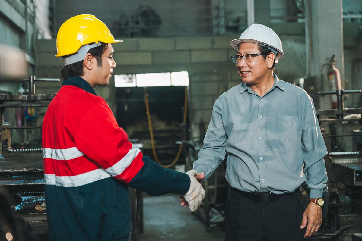 Steel contractor and worker coordinating onsite installation inside an industrial facility for structural steel construction