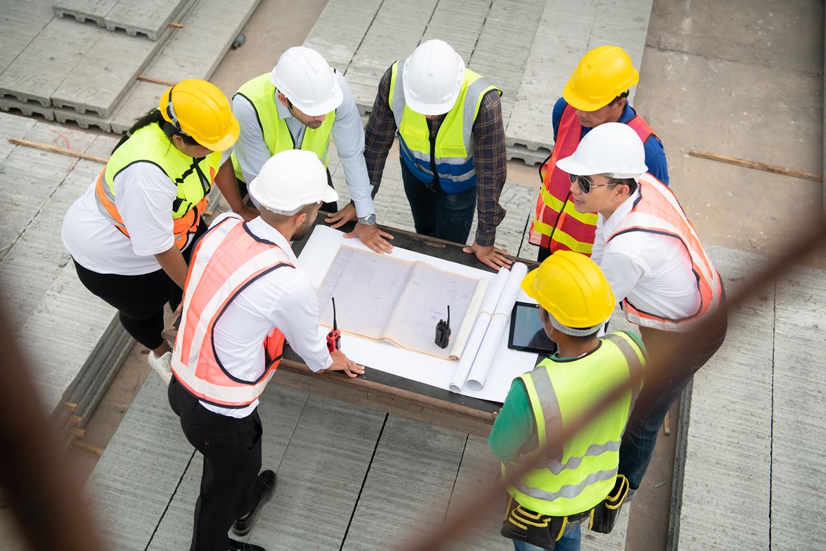 Construction professionals reviewing project plans together, representing supplier quality control and consistent material standards for custom designs