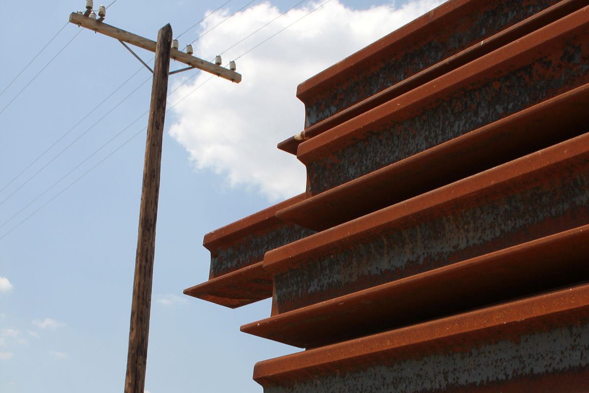 Bundled steel pipes and construction materials showing how low-quality supplies can affect project costs and replacement needs