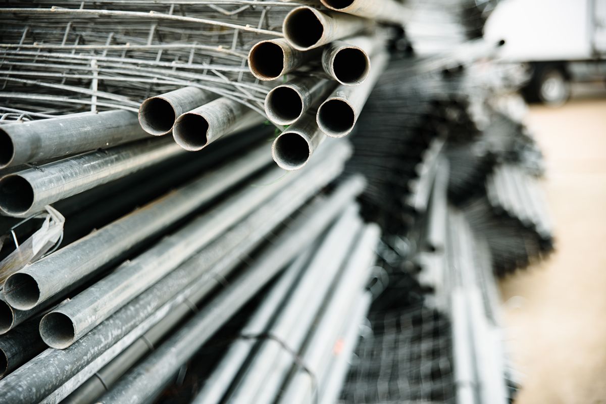 Rusting steel beams outdoors, representing the long-term risks of choosing cheap construction supplies over quality materials