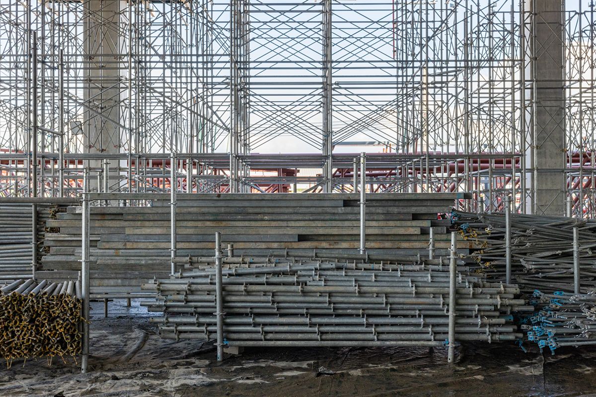 Scaffolding and stacked steel materials on a construction site, representing key steel products used in modern building projects